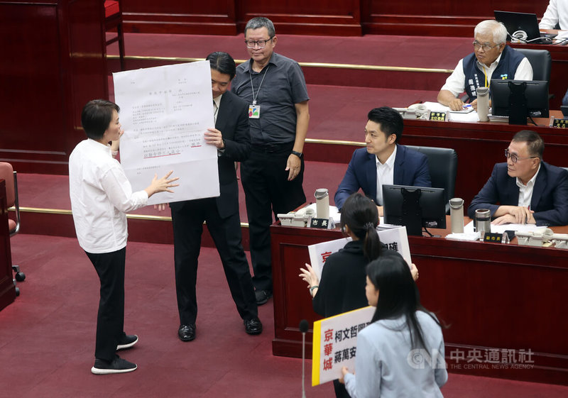 台北市長蔣萬安(前右2坐者)7日赴議會施政報告並備質詢,民主進步黨市議員簡舒培(左)等人拿出巨型道具公文,呼籲蔣萬安捍衛市民權益,勒令京華城停工。中央社記者鄭傑文攝 113年10月7日