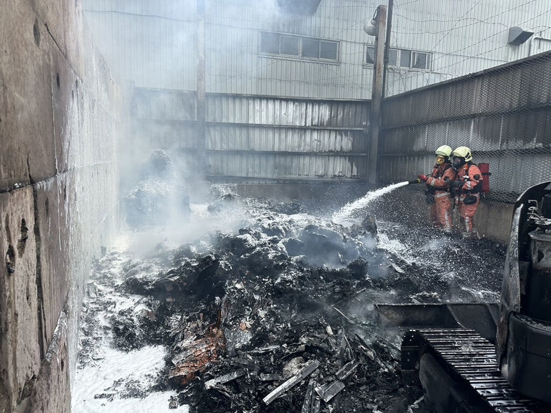 新竹市消防局10日下午受理新竹市香山區一間貴金屬回收工廠火警,出動人車馳援,大量戶外資源回收物品燒得一片漆黑,所幸未釀人員傷亡。(警消提供)中央社記者魯鋼駿傳真 113年10月10日