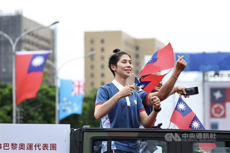 巴黎奧運女子拳擊金牌選手林郁婷隨著車隊揮舞國旗進場。中央社記者翁睿坤攝 113年10月10日