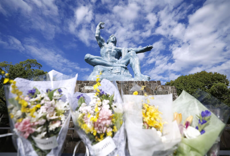 圖為日本長崎市和平雕像前擺放悼念花束。（共同社）