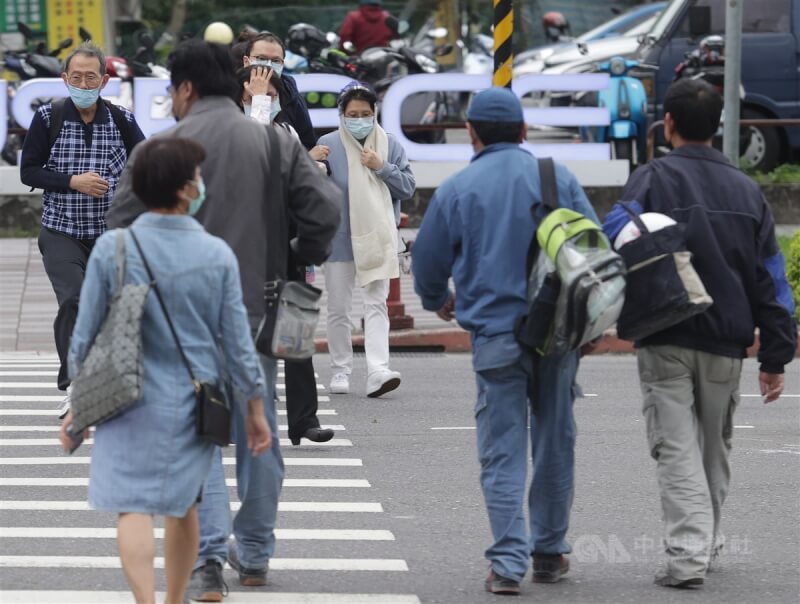 台北市信義區街頭民眾過馬路。（中央社檔案照片）