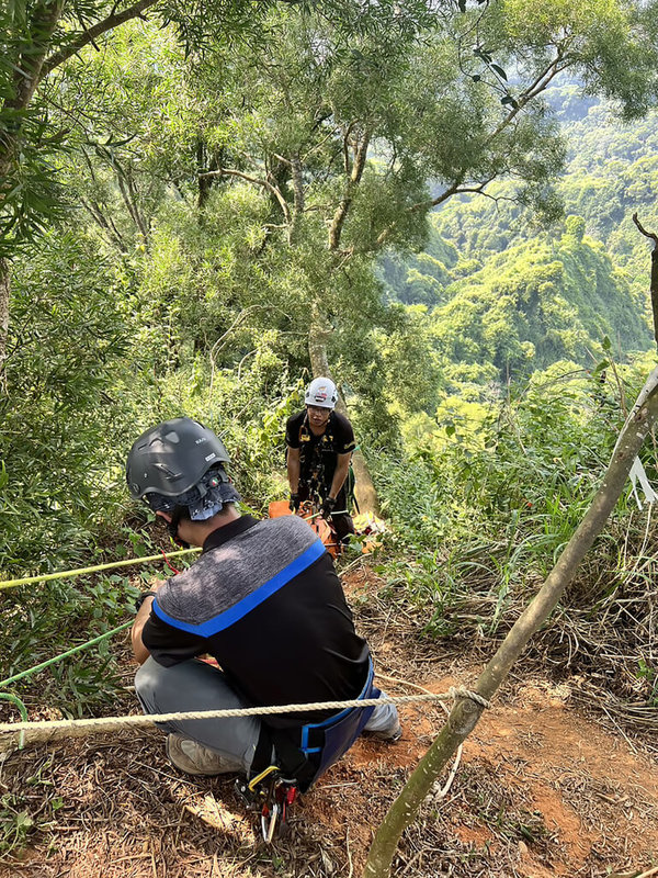 彰化縣1對夫妻13日上午到南投縣名間鄉爬山，57歲劉姓妻子墜落邊坡；由於現場小路陡峭又為沙子路面，不利行走，消防人員架設邊坡拖拉系統，下切近50公尺接觸劉女，發現其已失去生命徵象，之後利用捲式擔架運送，拖拉上平面道路。（南投縣消防局提供）中央社記者鄭維真傳真  113年10月13日