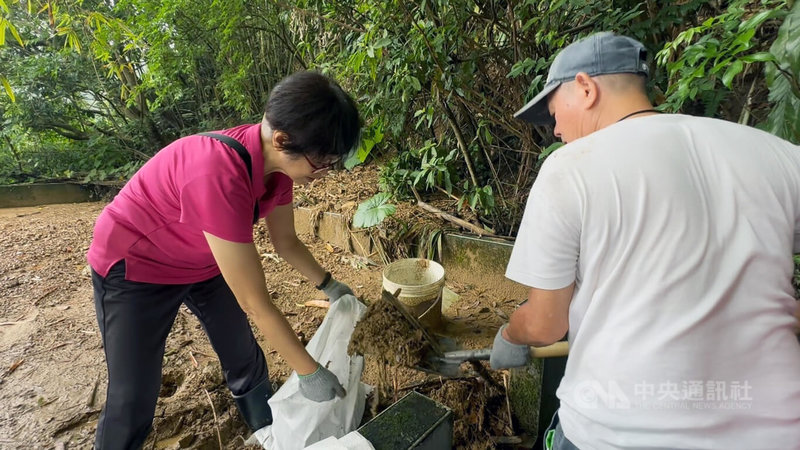 颱風山陀兒帶來豪雨，造成基隆市信二路36巷邊坡滑動，土石沖入民宅，獨居的67歲高姓女子住家走道、屋頂等處堆滿泥土，2週後仍無法回家居住；民進黨市議員陳宜、鄭文婷17日號召志工到場幫忙清理家園。中央社記者王朝鈺攝  113年10月17日