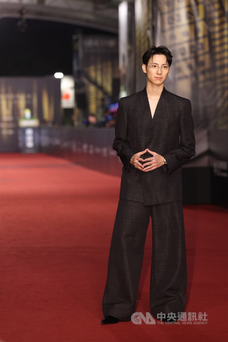 演員彭千祐以黑色西裝搭配超寬寬褲與無框眼鏡亮相紅毯,開心留影。中央社記者張新偉攝 113年10月19日