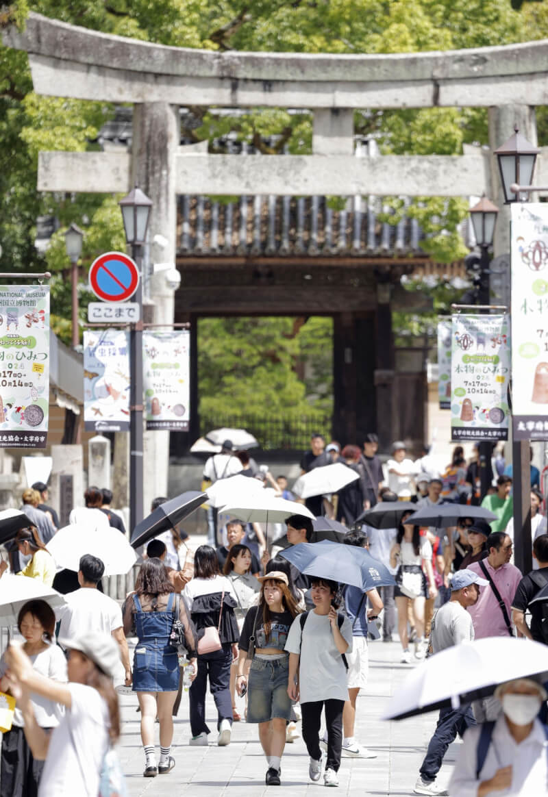 今年8月福岡太宰府遊客撐傘遮陽。（共同社）