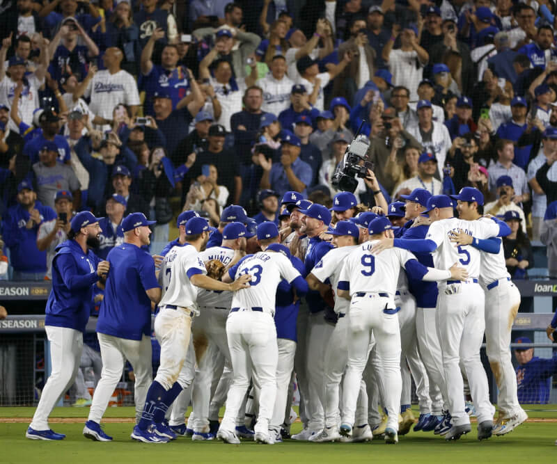 MLB道奇隊20日以10比5擊敗紐約大都會拿下國聯冠軍，進軍世界大賽。賽後全隊激動擁抱慶祝。（共同社）