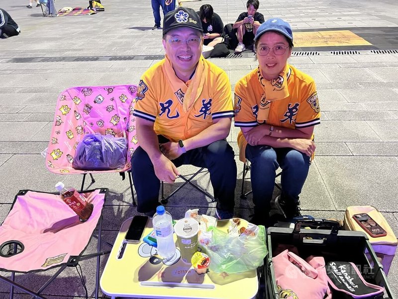 中華職棒總冠軍賽第4戰23日移師台南棒球場,台中市政府在府前廣場直播賽況,邀請中信兄弟隊球迷來助陣,吸引民眾參與,蔡姓夫妻檔穿起兄弟球衣,備妥飲料、滷味及鹽酥雞等前往觀賽。中央社記者郝雪卿攝 113年10月23日