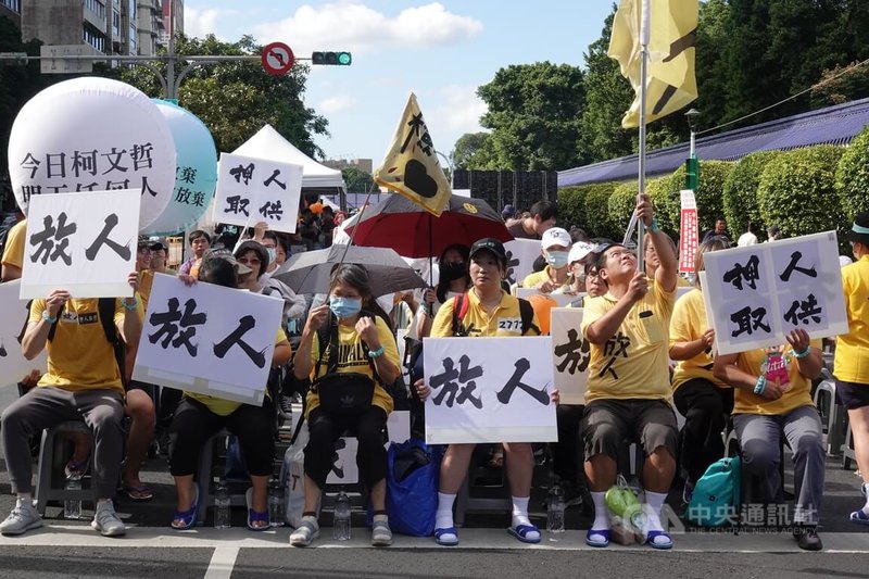 民眾黨27日在台北市愛國東路封街舉辦萬聖節活動「賴政府,搞什麼鬼?」,參加民眾在會場舉牌抗議。中央社記者鄭傑文攝 113年10月27日