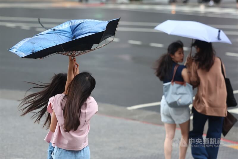 圖為10月2日新北市街頭行人手中雨傘不敵颱風山陀兒帶來的強風。（中央社檔案照片）