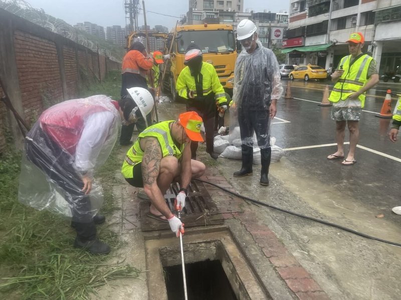 颱風康芮來襲，高雄市環保局加強全市側溝清疏，適逢澳洲消防員來台交流，一行11人31日主動加入側溝清疏防災作業，體驗人工器具挖溝、沖吸溝泥車操作及搬運溝泥等。（高雄市環保局提供）中央社記者洪學廣傳真  113年10月31日