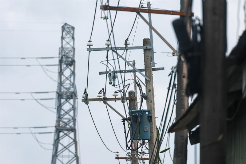 圖為新北市蘆洲一處電線桿與遠處的高壓電塔。（中央社檔案照片）