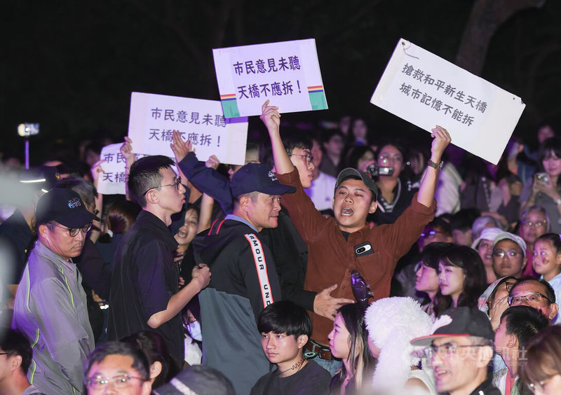 台北市政府日前決議拆除和平新生天橋，有民眾不滿組成團體「守護和平新生天橋」，部分成員2日晚間在白晝之夜活動現場持標語向市長蔣萬安抗議，後續被維安警察帶離現場。中央社記者謝佳璋攝 113年11月2日