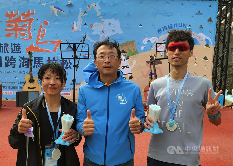 2024菊島澎湖跨海馬拉松3日登場,全馬男子組由日本濱康孝(右)稱王,全馬女子組由澎湖劉小琪(左)封后,兩人與澎管處長洪志光(中)合影。中央社 113年11月3日