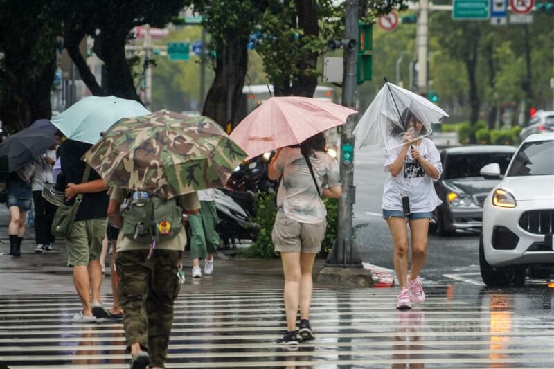 圖為台北市信義區街頭民眾撐傘過馬路。（中央社檔案照片）