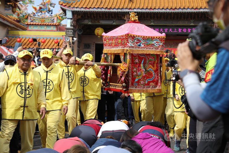 「粉紅超跑」白沙屯拱天宮媽祖8日到高雄鳳山區展開3天的「賜福鳳城」遶境，下午1時許自鳳邑開漳聖王廟啟程時，信眾紛紛在廟門前跪地等待「鑽轎腳」。中央社記者張已亷攝  113年11月8日