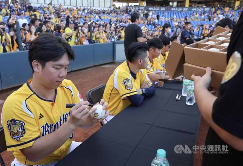 中華職棒中信兄弟隊9日舉辦封王遊行感謝祭，下午在台中洲際棒球場舉行球員簽名會，球員詹子賢（前左）為球迷在棒球上簽名。中央社記者趙世勳攝　113年11月9日