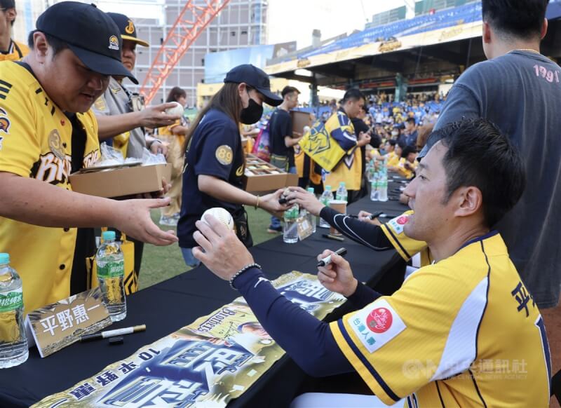 中華職棒中信兄弟隊9日舉行封王遊行感謝祭，下午在台中洲際棒球場舉辦球員簽名會，總教練平野惠一（前右）將簽過名的棒球遞給球迷。中央社記者趙世勳攝　113年11月9日