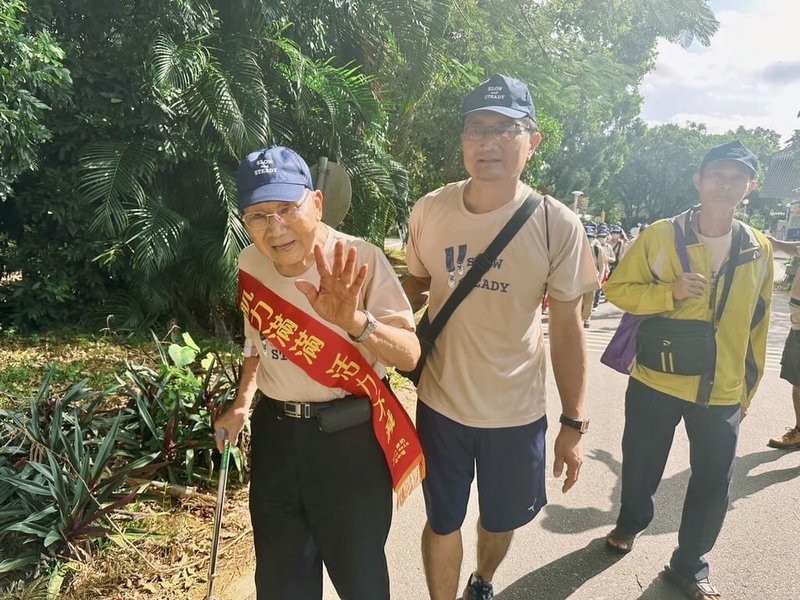 弘道老人福利基金會舉辦「爺奶Color Walk」健走活動，10日在東海大學登場。99歲戴紀彬（左）是最高齡參賽者，再過1個月將邁入100歲的他，在兒子（前右）陪伴下挑戰健走3公里。（弘道老人福利基金會提供）中央社記者趙麗妍傳真  113年11月10日