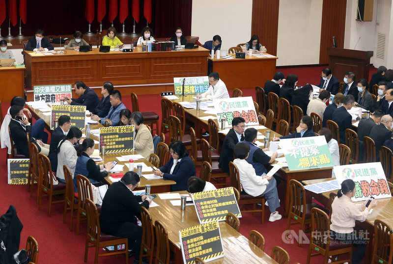 立法院財政委員會11日由民進黨立委賴惠員(後左4)擔任本週輪值召委,會議一開始,朝野立委各自拿出準備好的手板、標語表達立場。中央社記者郭日曉攝 113年11月11日