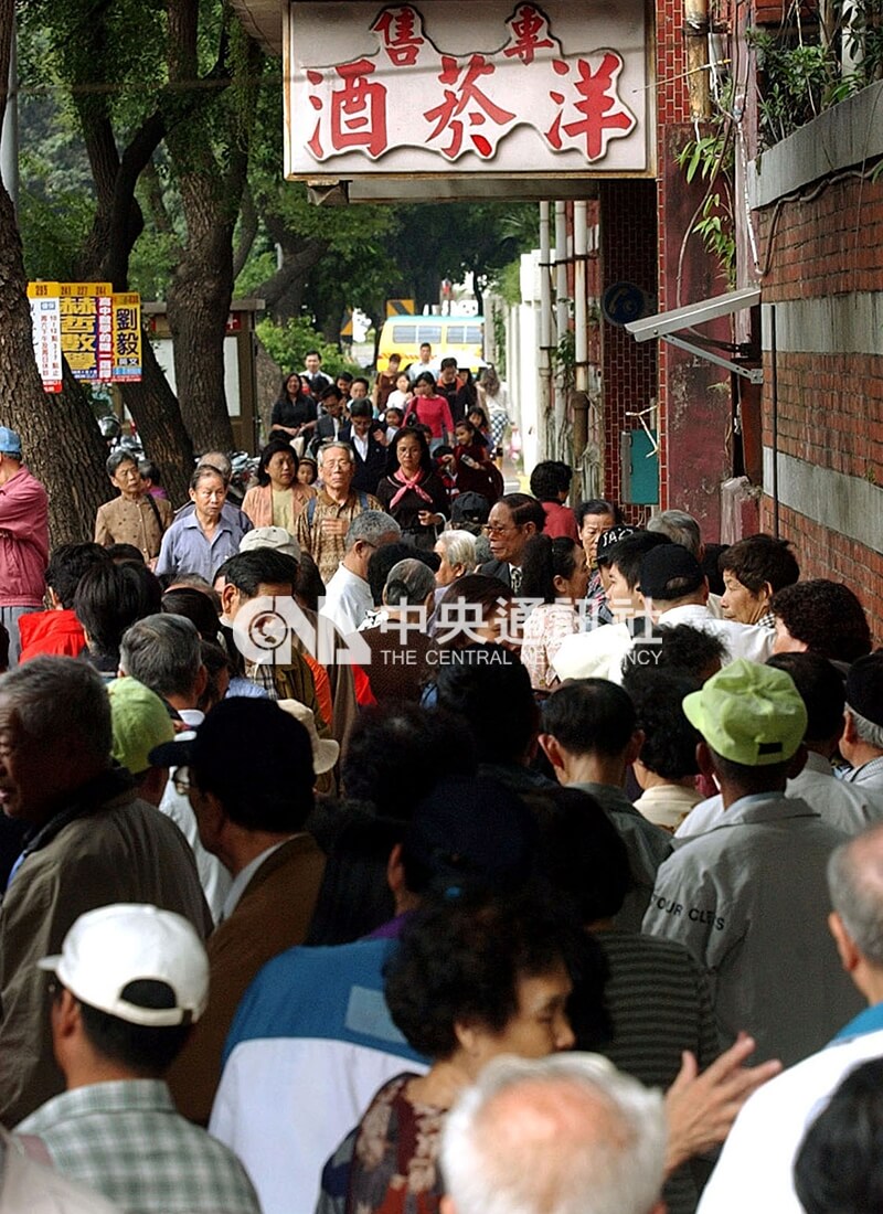 民眾預期台灣加入WTO後米酒價格會飆漲，菸酒公賣局窗口一早就有民眾排隊，等待4、5個小時才能買到米酒。中央社記者孫仲達攝 90年11月13日