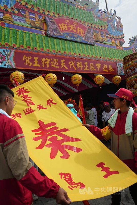南州迎王平安祭典13日登場,上午在林邊鄉崎峰海灘進行請王儀式,廟方施放彩煙,在帥旗上寫下「奉玉旨代天巡狩秦王駕」,宣告「秦府大千歲」駕臨。中央社記者黃郁菁攝 113年11月13日