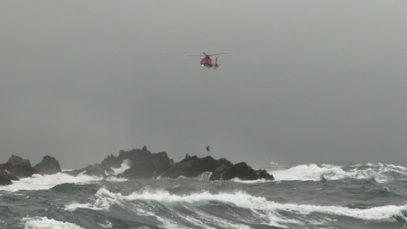 基隆嶼四角礁16日發生7名釣客遭浪襲落海，其中6人已獲救，另1人疑似失去意識，於海面上待援。案發現場另有8人在礁石上待援，空中勤務總隊直升機實施吊掛救援。（海巡署第二巡防區指揮部提供）中央社記者沈如峰基隆傳真 113年11月16日