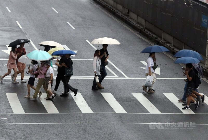 圖為台北市民眾撐傘穿越馬路。（中央社檔案照片）