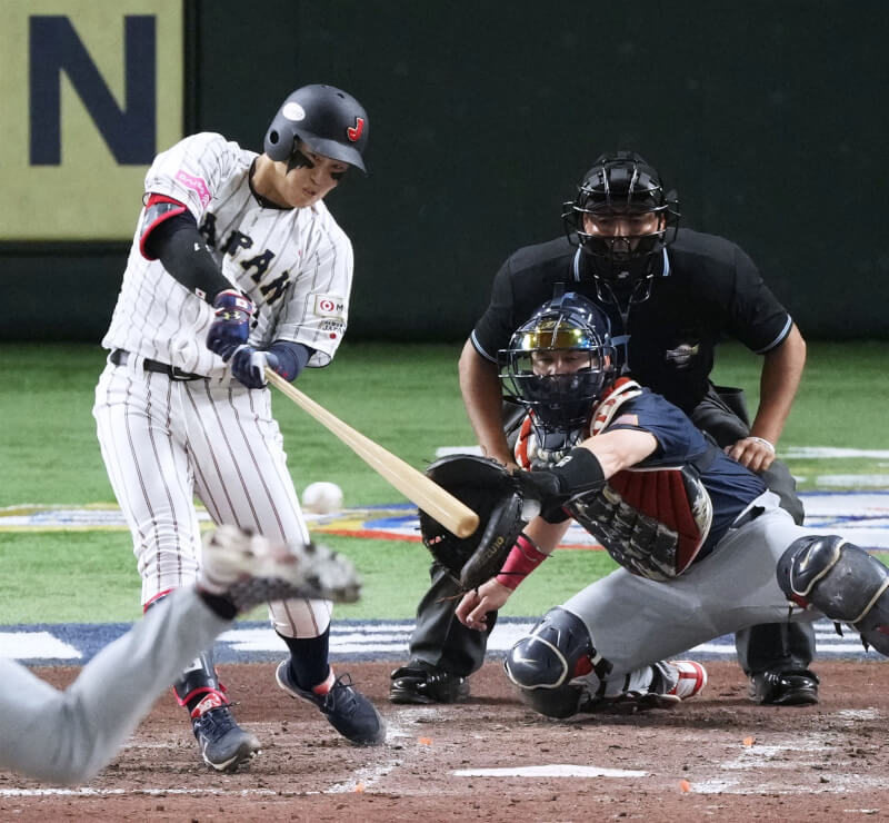 日本今天在世界12強棒球賽複賽首戰對上美國，打者小園海斗（揮棒者）扛出雙響砲，單場進帳7分打點。（共同社）