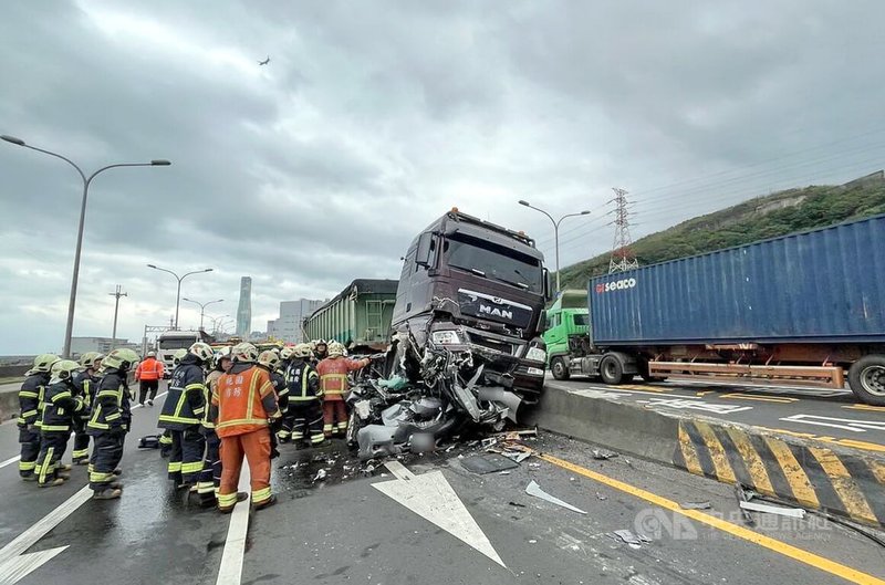 新北市林口區台61線林口火力發電廠附近路段，22日中午發生兩輛砂石車與一輛小客車車禍，遭夾擊的轎車嚴重變形，消防人員趕抵救援。（翻攝畫面）中央社記者黃旭昇新北市傳真  113年11月22日