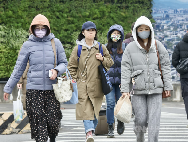 圖為走在台北市中正區街頭的民眾穿上保暖外套、戴帽子禦寒。（中央社檔案照片）