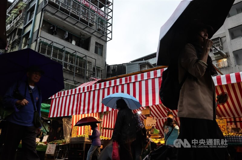 北市虎林街傳統市場午後21日陰雨綿綿，採買民眾撐傘遮擋雨勢。中央社記者趙世勳攝 113年11月21日