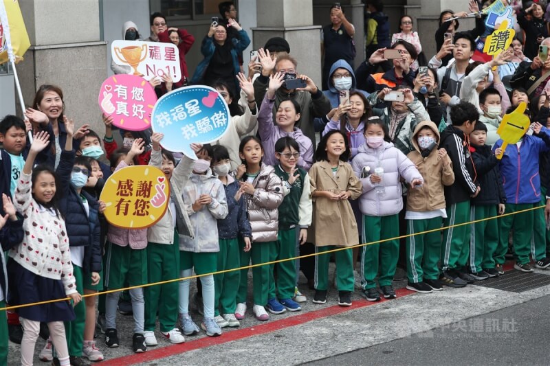 學童在路旁等待遊行隊伍，舉字牌為台灣隊加油打氣。中央社記者吳家昇攝 113年11月26日