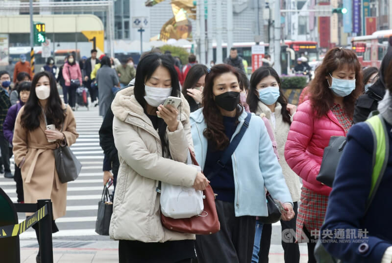 圖為台北市西門町商圈民眾穿上外套禦寒。（中央社檔案照片）