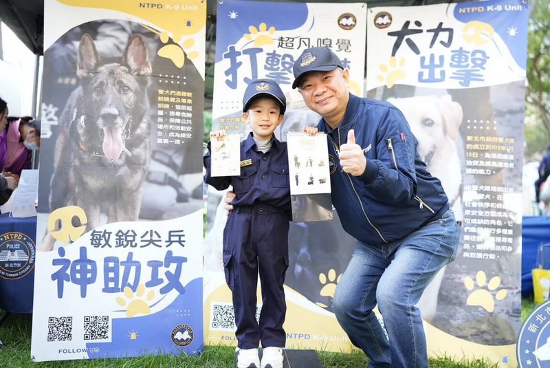 新北市動物保護防疫處30日舉辦「2024毛寶貝魔幻幸福耶誕趴」,市警局現場發送警犬桌曆大受歡迎,警局長廖訓誠(右)並與領取桌曆的小朋友互動合影。(新北市警察局提供)中央社記者黃旭昇新北市傳真 113年11月30日