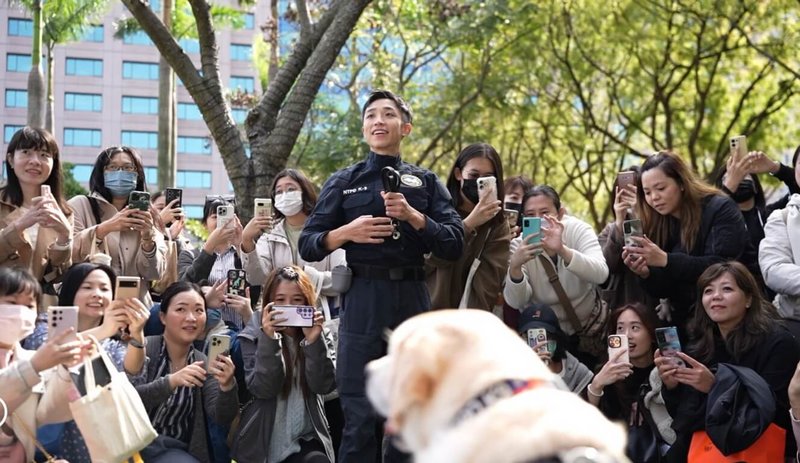 退休警犬「福星」30日現身新北市參與「2024毛寶貝魔幻幸福耶誕趴」,與領犬員林志倫(中)互動,也受到大批民眾熱烈歡迎。(新北市警察局提供)中央社記者黃旭昇新北市傳真 113年11月30日
