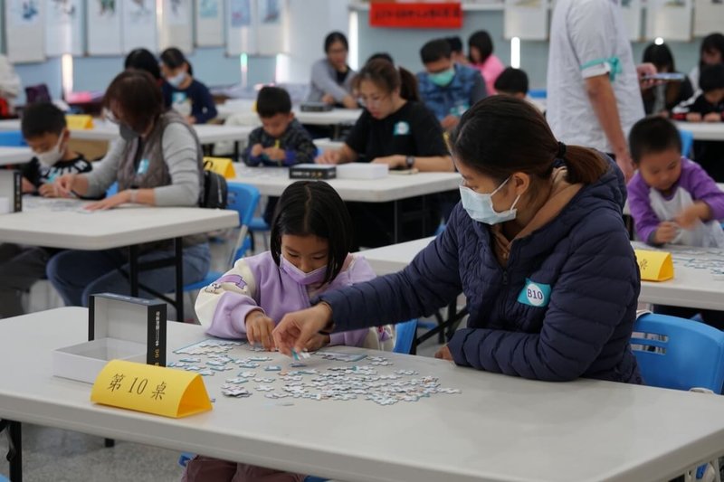 民眾黨澎湖縣黨部小島教育智庫協會主辦的「小島盃拼圖大賽」1日在馬公市重光社區活動中心登場，參與的親子組們聚精會神，絞盡腦汁拼圖。（民眾黨澎湖縣黨部提供）中央社  113年12月1日