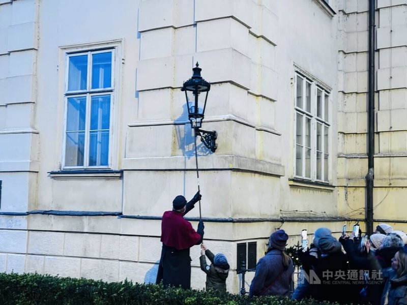 點燈人正準備一一點亮查理大橋周邊的煤氣燈,也讓小朋友參與其中。中央社記者劉郁葶布拉格攝 113年12月2日