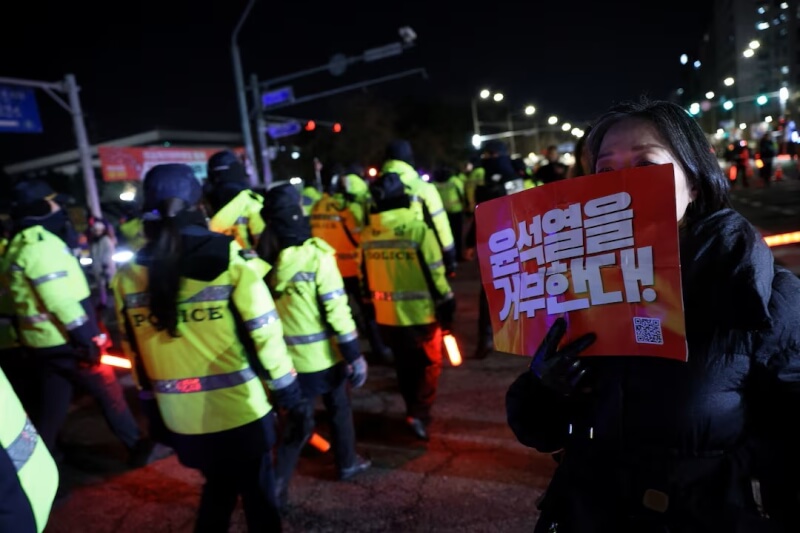 韓國民眾4日舉著標語在國會外抗議。（路透社）