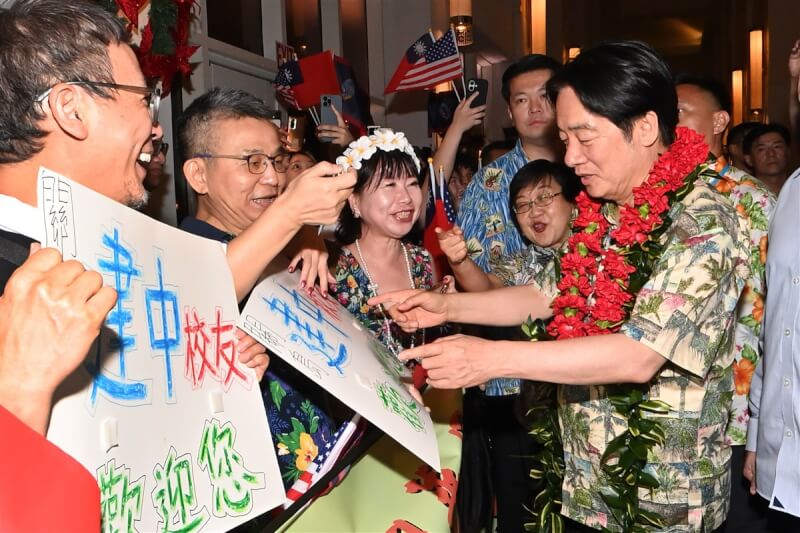 總統賴清德(前右)結束太平洋友邦吐瓦魯的訪問,搭機於關島當地時間4日晚間抵關島過境,大批僑胞熱情歡迎賴總統到來,有民眾還自製「建中校友歡迎您」標語。(隨團媒體提供)中央社記者翁睿坤關島傳真 113年12月4日