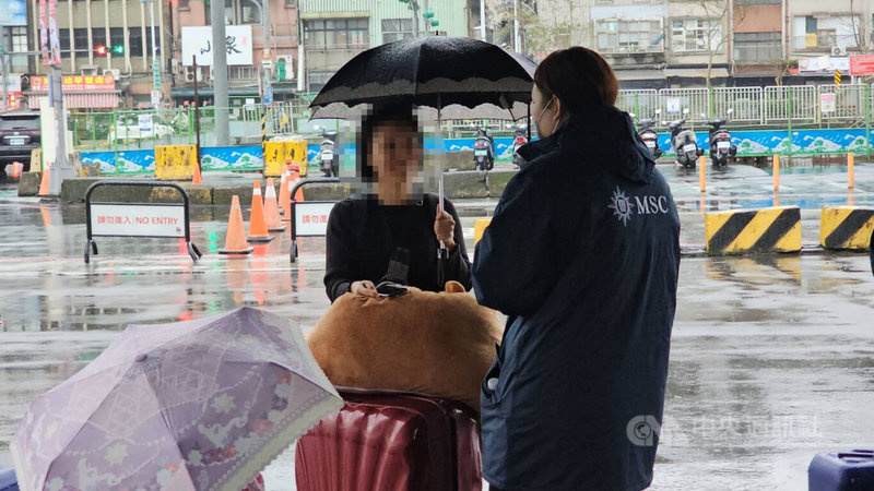 郵輪地中海榮耀號因故障滯留日本那霸，1名日籍女子8日上午撐傘、拖著行李到基隆港西岸碼頭準備搭船時，得知航程取消感到驚訝。中央社記者王朝鈺攝  113年12月8日