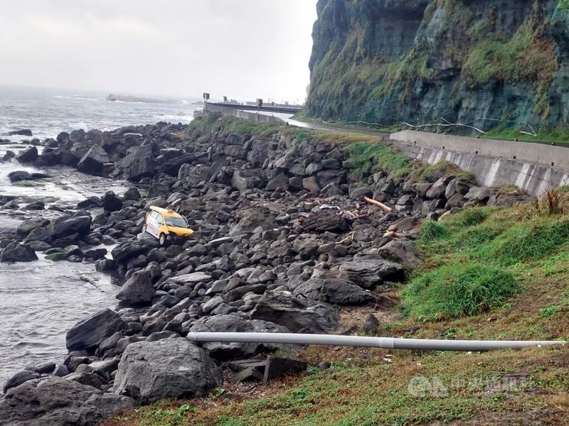 一輛計程車10日下午在台2線83.6公里處不明原因翻覆至護欄外、墜落在深約6公尺處的礁石區,消防獲報到場救出受困男子,送醫治療。(翻攝畫面)中央社記者黃旭昇新北市傳真 113年12月10日