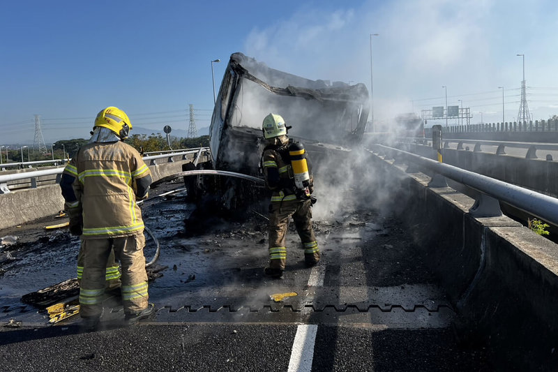 一輛砂石車11日上午行經台南市官田區國道3號北向轉台84線西向匝道，疑似自撞護欄後側翻起火，消防局獲報立即派遣人車到場灌救。（讀者提供）中央社記者楊思瑞台南傳真  113年12月11日