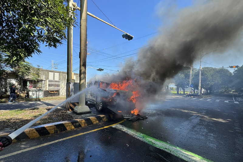 台南市柳營區義士路二段11日發生2輛自小客車碰撞事故，其中1輛卡在中央分隔島並起火，消防人員到場灌救。（讀者提供）中央社記者楊思瑞台南傳真  113年12月11日