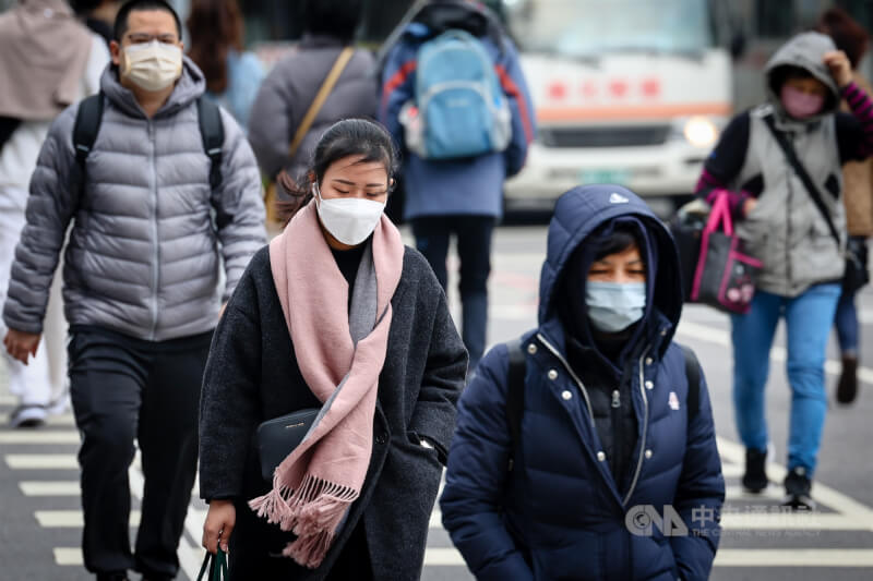 圖為新北市板橋區外出民眾穿外套、戴圍巾禦寒。（中央社檔案照片）