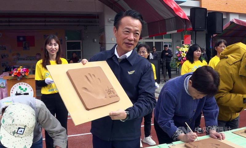 嘉義縣南靖國小14日舉行第77屆校慶活動並啟用新建校舍,縣長翁章梁(中)出席剪綵,並在陶板上留下手印、落款,留下紀念。中央社記者蔡智明攝 113年12月14日