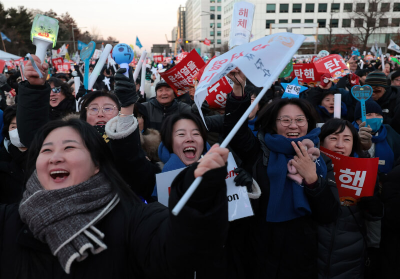 圖為汝矣島韓國國會外聚集民眾，在彈劾案通過後歡呼雀躍。（韓聯社）