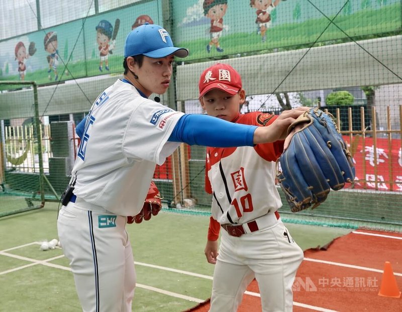 19歲投手孫易磊(左)2023年與日本職棒北海道日本火腿鬥士隊簽約,今年季後返台,受台灣世界少棒聯盟(TLLB)邀請,17日回到母校東園國小參加日本火腿棒球教室活動,指導少棒球員。中央社記者張皓安攝 113年12月17日