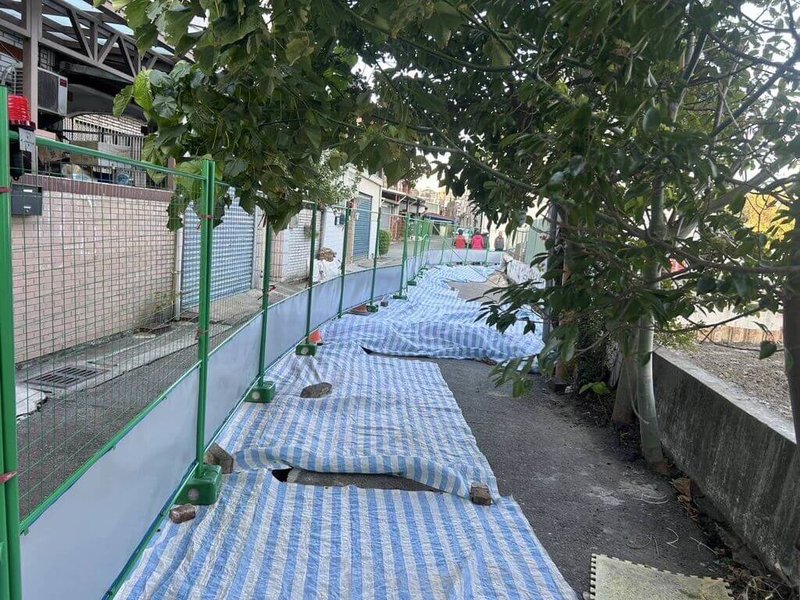 苗栗縣政府工商發展處18日指出,竹南鎮順興路77巷建案開挖基地土方,導致早年興建的擋土牆傾斜龜裂,進而讓旁邊道路出現沉陷傾斜,目前已先於沉陷處設置防水布、圍籬與警示標誌。(苗栗縣政府提供)中央社記者管瑞平傳真 113年12月18日