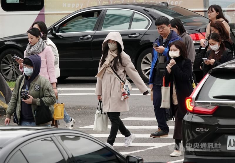 台北市南港軟體園區民眾穿大衣、戴帽子禦寒。（中央社檔案照片）