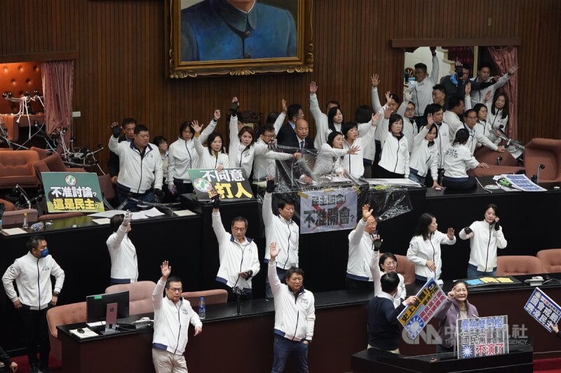 朝野立委20日為選罷法等修正草案爆發多次推擠衝突，立法院長韓國瑜（後中）在國民黨立委保護下宣布開會。表決院會議程時，由於場面混亂，韓國瑜裁示進行舉手表決。中央社記者徐肇昌攝 113年12月20日